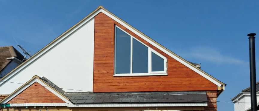 Modern loft extension with contemporary cedar cladding and triangle window in Oxfordshire by CJB Renovations